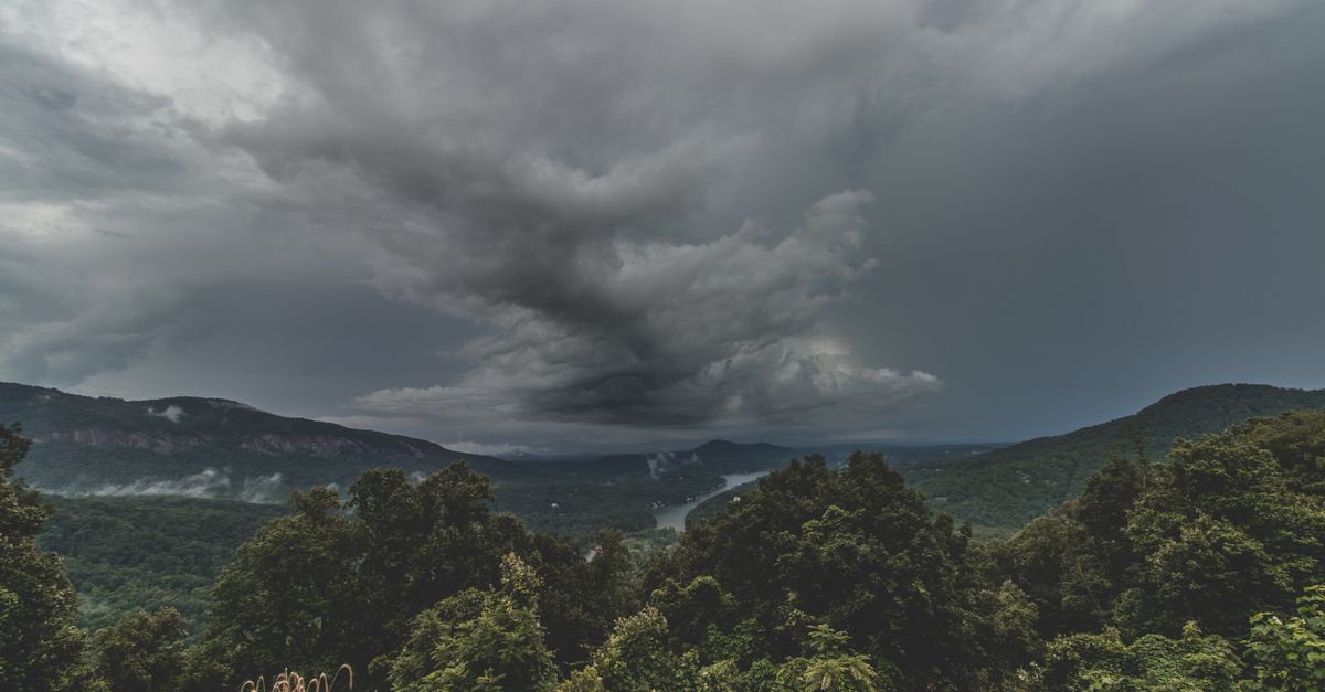 A dramatic storm brewing over a lush mountain landscape in the United States, capturing the intensity of nature.