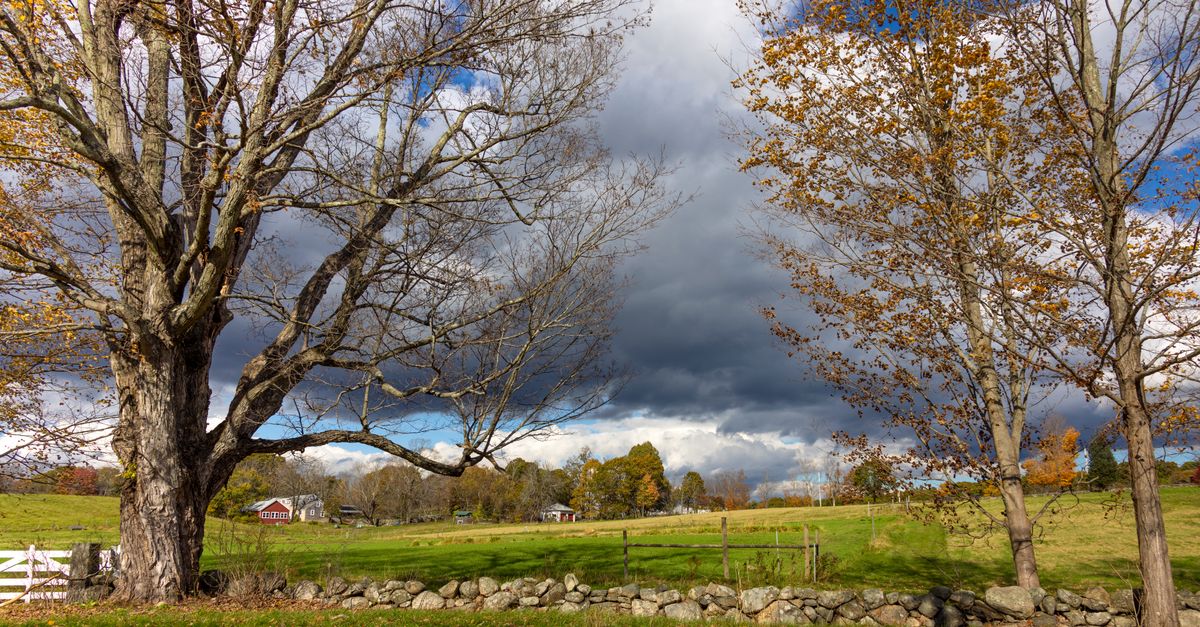 Picturesque view of rural landscape in Southborough, Massachusetts featuring autumn trees and a cloudy sky.