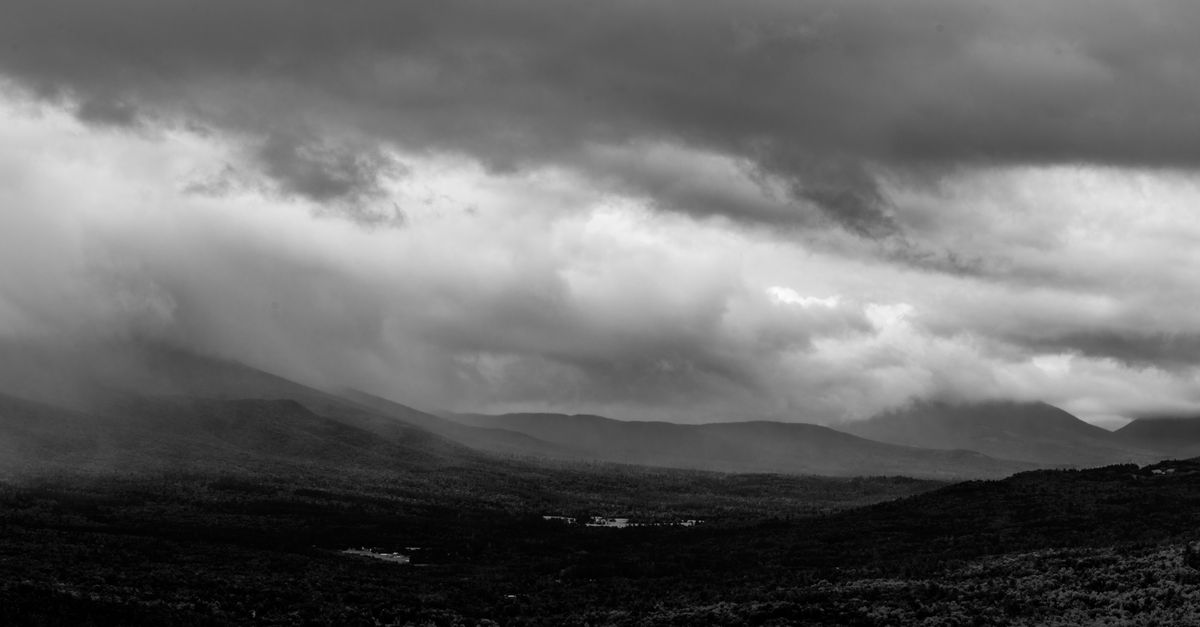 Dramatic black and white photo of mountains under dark, stormy skies in New Hampshire.