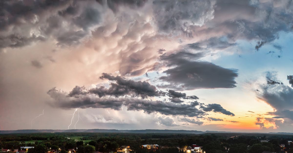 A dramatic thunderstorm over Nelson, WI with lightning and a vibrant sunset.